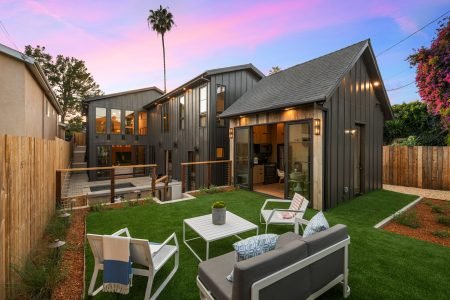 A modern backyard with stylish patio furniture and a contemporary home at sunset. Southern California
